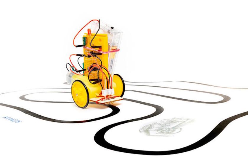 Gelber zweirädriger Fahrroboter aus dem FRANZIS-Adventskalender, der einer schwarzen Linie auf weißem Untergrund folgt.