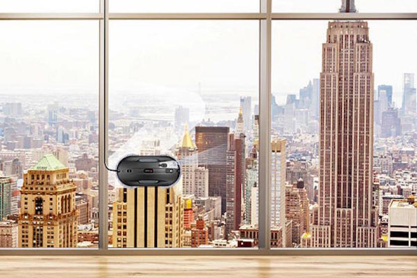 Fensterputzroboter HOBOT im Einsatz an einer Glasfassade mit Blick auf eine Großstadtskyline; das Gerät säubert die Fenster automatisch.
