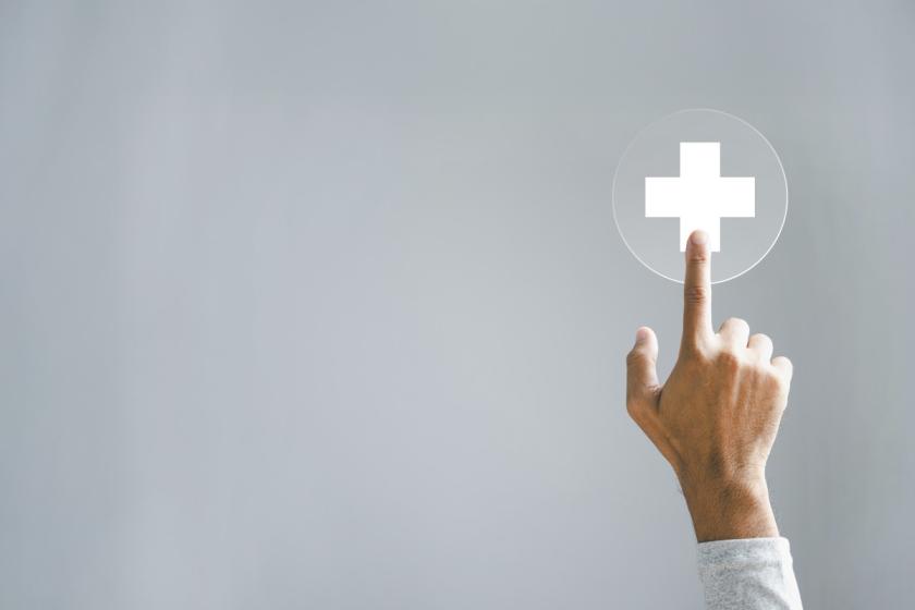Die Hand berührt ein virtuelles Pluszeichen, das Positivität symbolisiert.