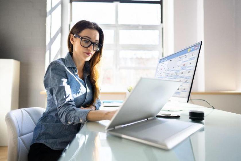 Symbolbild: Frau arbeitet am Laptop mit zusätzlichem Monitor, stellvertretend für Online-Seminare zur Netzwerkverkehrsanalyse mit Wireshark.