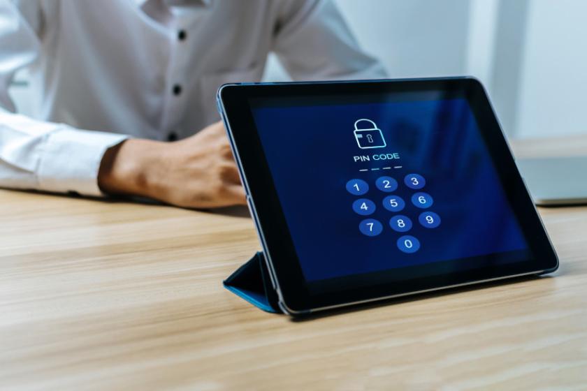 Ein Tablet steht auf einem Tisch mit einer Aufforderung zur PIN-Eingabe auf dem Bildschirm.