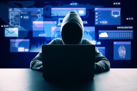 Ein Hacker mit Kapuzenpulli sitzt vor einem Laptop. Im Hintergrund schweben stilisierte Bildschrimfenster.