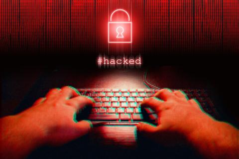 Hände tippen in rot gefärbt auf einer Tastatur vor einem stilisierten Vorhängeschloss und dem Schriftzug Hacked..