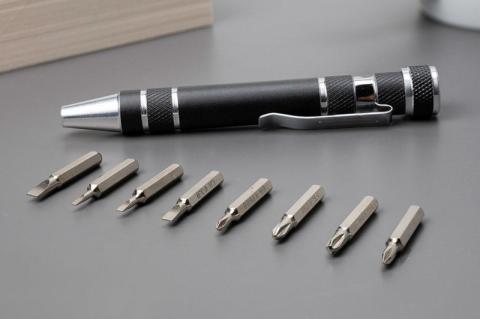 Ein Schraubendeher-Set mit acht verschiedenen Bits liegt ausgebreitet auf einem Tisch.