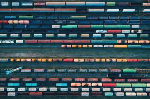 Luftaufnahme eines großen Rangierbahnhofs mit zahlreichen abgestellten Güterwaggons – Symbol für die Komplexität der Trassen- und Fahrplanplanung im Schienenverkehr. (Quelle: denisbelitsky – 123RF)