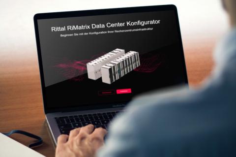 Ein Mann sitzt vor einem aufgeklappten Laptop mit einem Symbolbild für den RiMatrix Data Center Konfigurator auf dem Bildschirm.