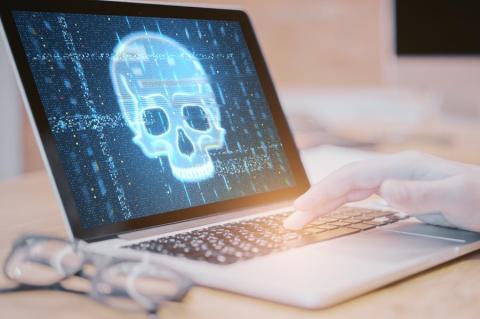 Aufgeklapptes Laptop mit einem Totenkopf auf dem Bildschirm. (Quelle: peshkov – 123RF)